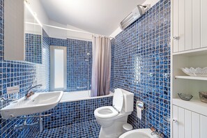 Bañera con ducha, bidet, toallas, jabón