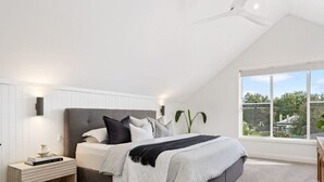 A bedroom with a bed, bedside table, and a large window with a view. - Stunning Family Home on Prince - Close to CBD! (Orange)