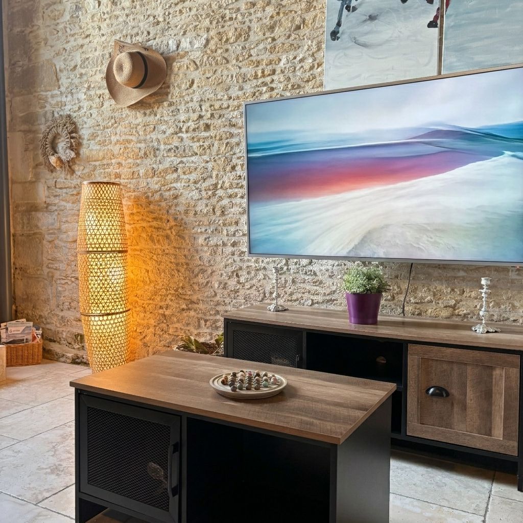 Een kamer met een stenen muur, een televisie, een houten tafel, een kast en een decoratieve lamp.