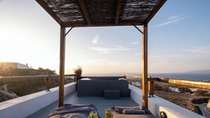 A rooftop terrace with a view of the sea, a wooden pergola, and a seating area with cushions and a drink. - Prive by Noelia Suites | Sunset View |Hot Tub-2Pax (Finikia)