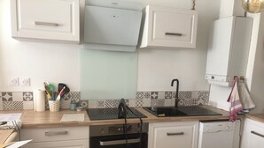 A modern kitchen with white cabinetry, a black Bosch dishwasher, and a black Bosch oven. - Joli Appartement T2 Vannes / 2 à 4 Personnes (Vannes)