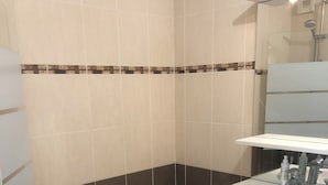 A bathroom with a bathtub, a sink, and a mirror. - Joli Appartement T2 Vannes / 2 à 4 Personnes (Vannes)