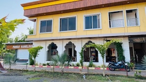 A two-story building with a yellow facade and a sign reading "PAWAR HANDLOO". - Payal Palace (Maheshwar)