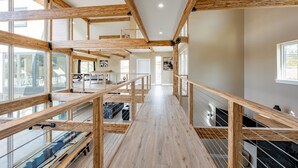 A spacious interior with high ceilings, wooden beams, and large windows. - New! Epic lakefront home with indoor pool! (McHenry)