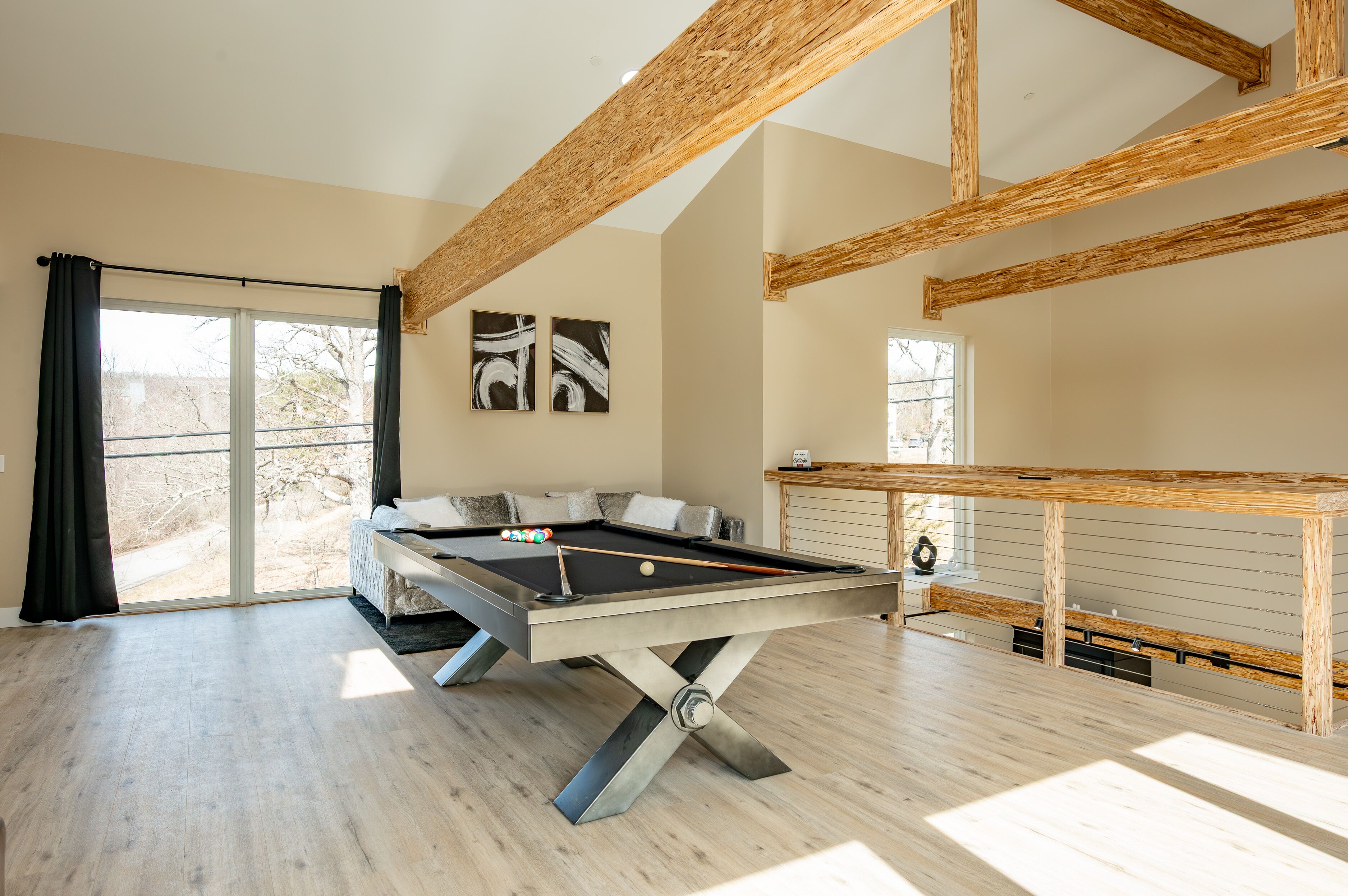 Une pièce spacieuse équipée d’une table de billard, d’un canapé et d’une table de jeu de fléchettes.