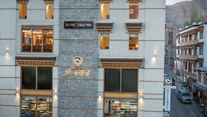 A hotel with a stone facade, large windows, and a sign reading "Hotel Dragon."
