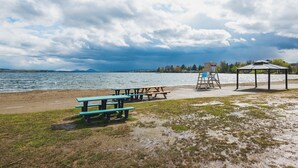 A lakeside picnic area with benches and a lifeguard stand. - Cozy and close to beach ,3 bedroom condo in Magog (Magog)