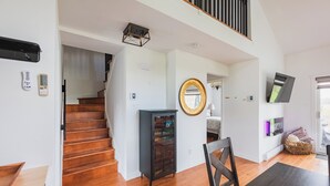 A modern interior with a staircase, a cabinet, a dining area, and a television. - Cozy and close to beach ,3 bedroom condo in Magog (Magog)