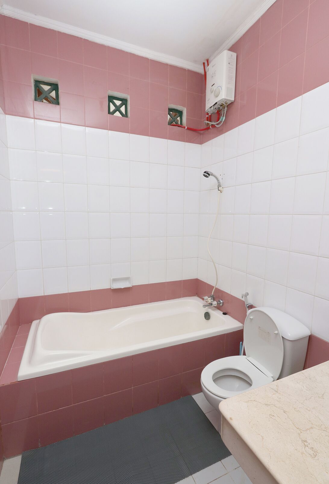 Ein Badezimmer mit Badewanne, Toilette und Duschkopf.