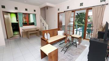 A spacious living room with a sofa, coffee table, and a TV stand.