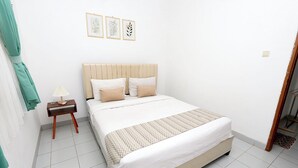 Ein ordentlich eingerichtetes Schlafzimmer mit Bett, Nachttisch und Wandleuchte.