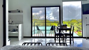 Een moderne kamer met balkon, een eethoek en een keuken.