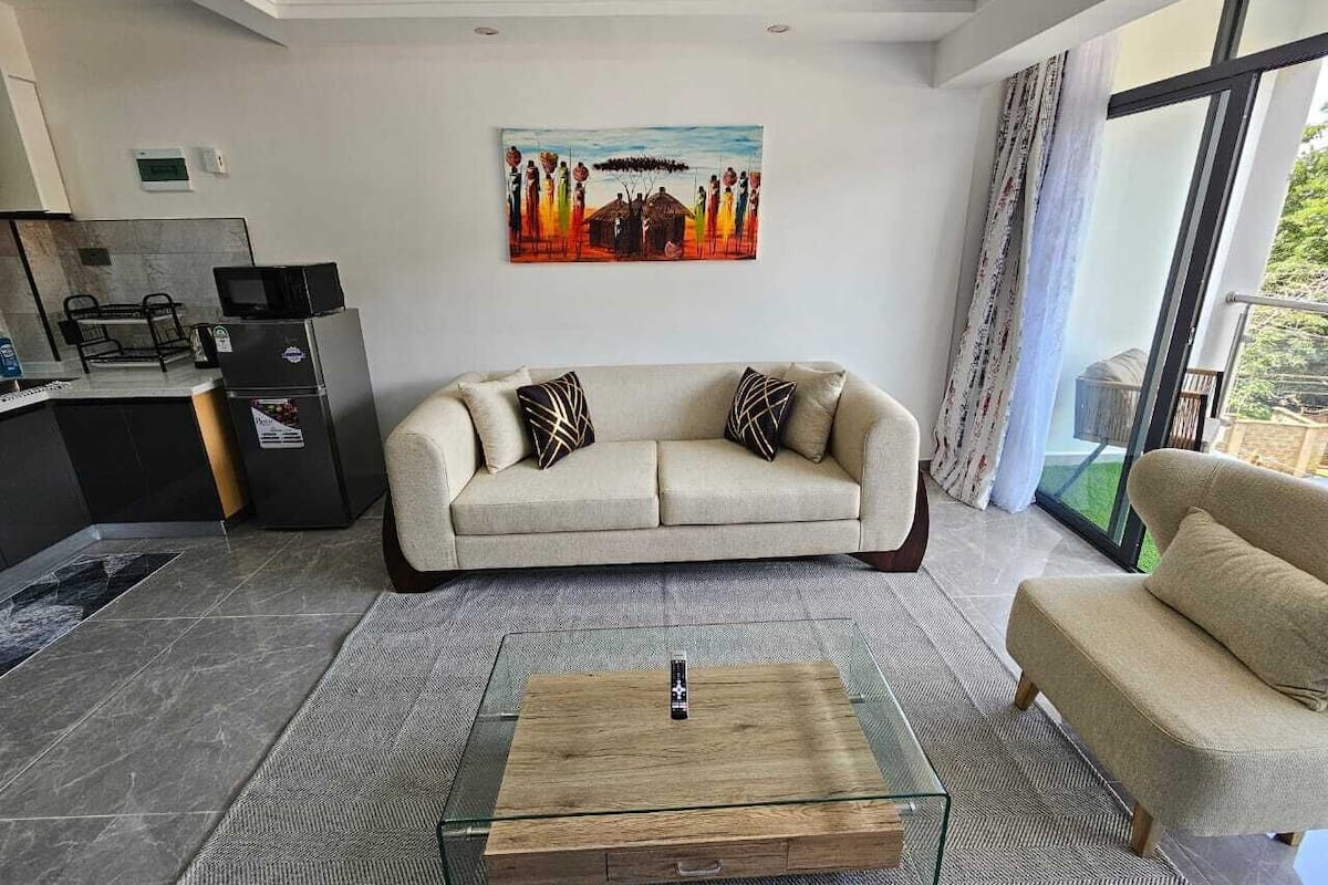 A modern living room with a sofa, a coffee table, and a painting on the wall.
