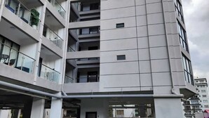 A multi-story parking garage with a modern building adjacent to it. - Lux Suites Gatundu Heights Kileleshwa (Nairobi)