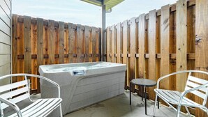 A hot tub with two metal chairs and a small table, surrounded by a wooden fence. - 5 Minutes From Dollywood/In DwTn Pigeon Forge (Pigeon Forge)