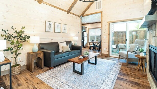A cozy living room with a wooden ceiling, a black sofa, a coffee table, and a fireplace. - 5 Minutes From Dollywood/In DwTn Pigeon Forge (Pigeon Forge)