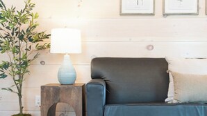 A living room with a dark blue sofa, a small wooden side table with a lamp, and a potted plant. - 5 Minutes From Dollywood/In DwTn Pigeon Forge (Pigeon Forge)