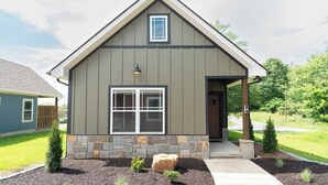 A single-story house with a gabled roof, a front porch, and a stone foundation.