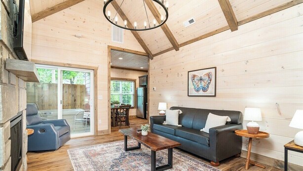 A cozy living room with a fireplace, a sofa, a coffee table, and a rug.