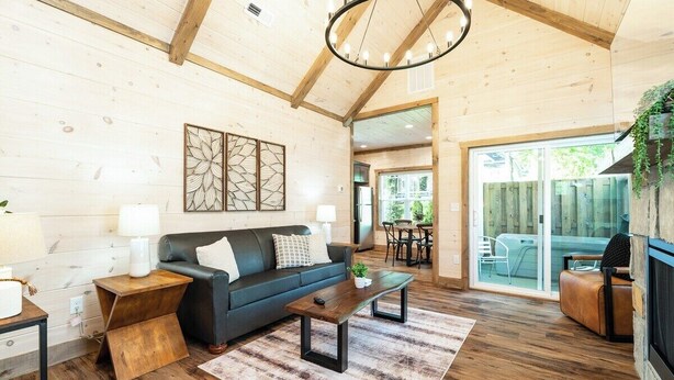 Un salon chaleureux avec un canapé foncé, une table basse en bois et une cheminée.