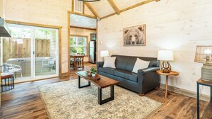 A spacious living room with a dark grey sofa, wooden coffee table, and a large window. - 5 Minutes From Dollywood/In DwTn Pigeon Forge (Pigeon Forge)