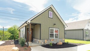 A single-story house with a gabled roof, a front porch, and a small front yard with landscaping.