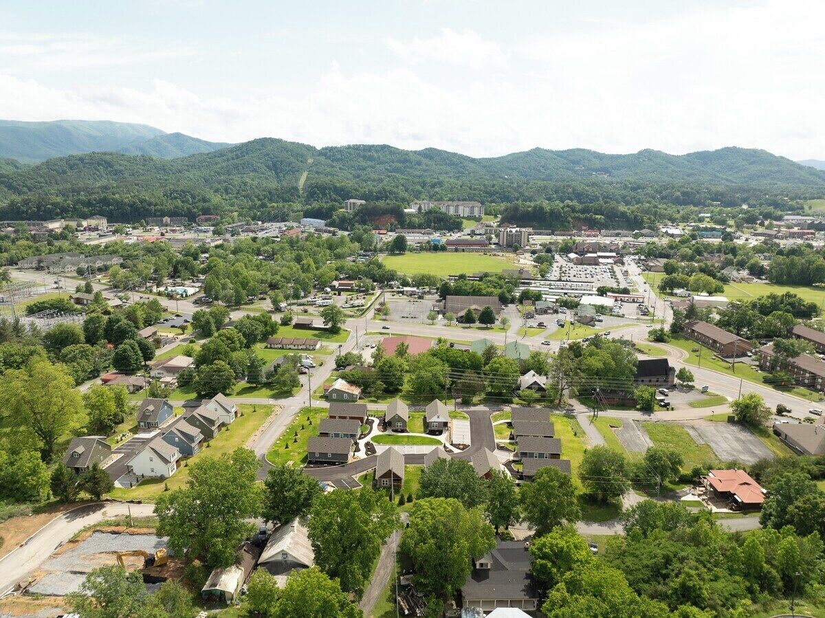 Un barrio residencial con casas, calles y un edificio grande a lo lejos.
