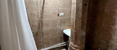A bathroom with a shower, toilet, and sink.