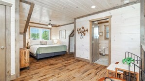 A bedroom with a bed, bedside table, and a window. There is a wooden floor and a ceiling fan. - 5 Minutes From Dollywood/In DwTn Pigeon Forge (Pigeon Forge)