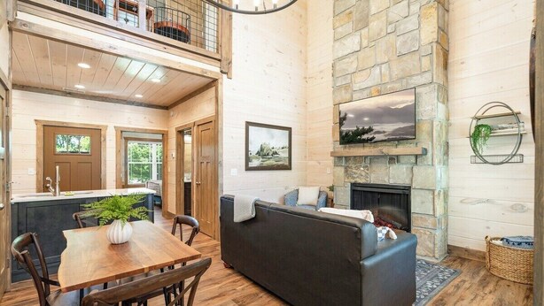 Ein gemütliches Interieur mit Essbereich, Kamin und Wohnzimmer mit Steinwand und Holzboden.