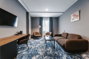 Tomannsrom – deluxe | Oppholdsområde | En 77-centimeters TV med kabel-kanaler samt filmkjøp