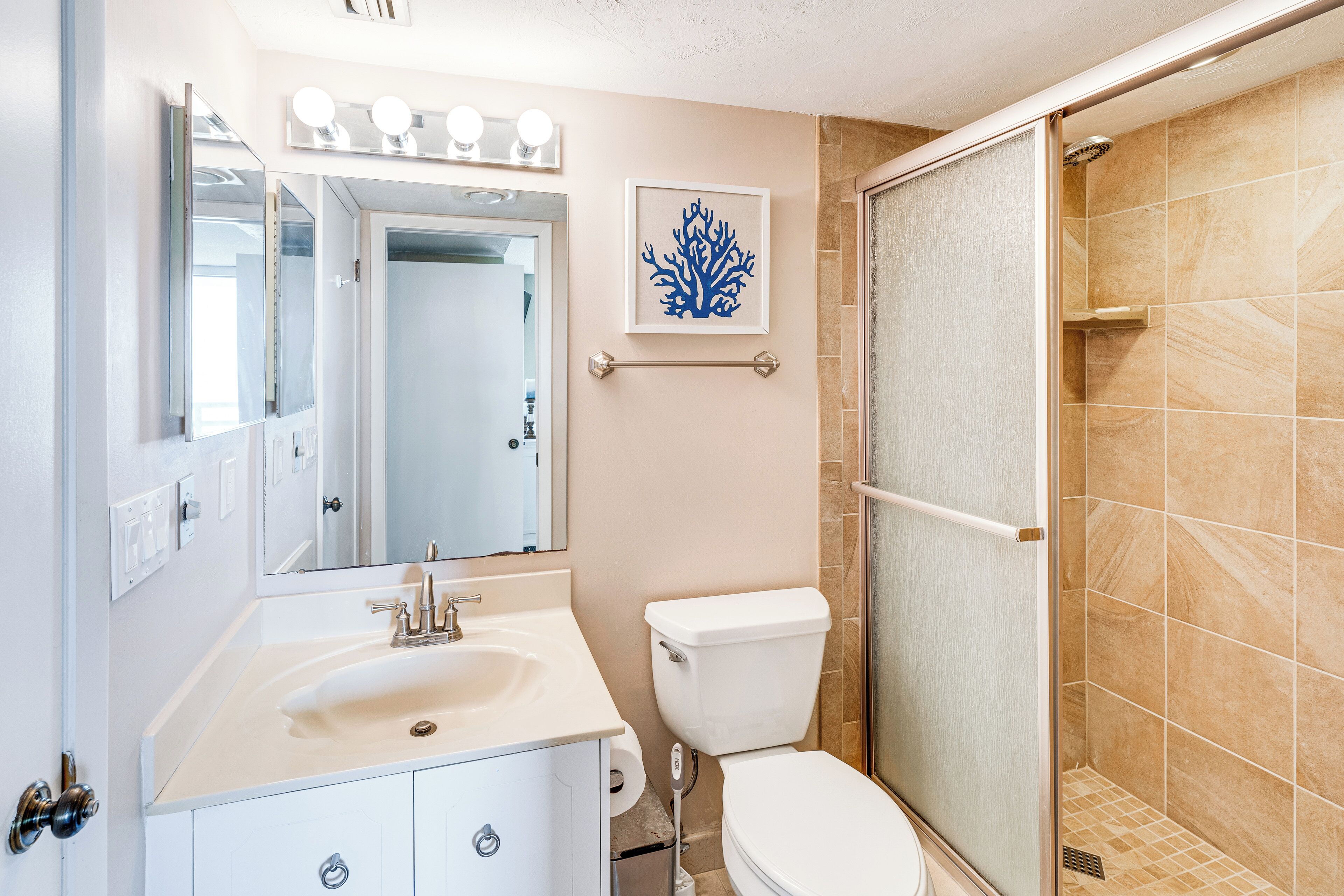 Ein Badezimmer mit Waschbecken, Spiegel, Toilette und Dusche.