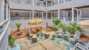 A multi-level outdoor patio with white railings, seating areas, and potted plants. - 1 Block to Beach: Myrtle Beach Condo w/ Pool! (Myrtle Beach)
