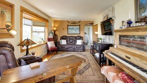 A living room with a piano, leather sofa, and a dining table. - Spacious Duluth Home ~ 4 Mi to Lake Superior! (Duluth)