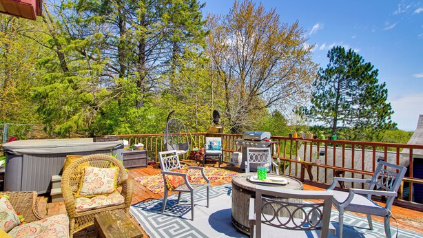 A deck with outdoor furniture, a grill, and a hot tub. - Spacious Duluth Home ~ 4 Mi to Lake Superior! (Duluth)