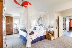 A bedroom with a canopy bed, a wooden dresser, a bedside table with a lamp, and a wardrobe. - Waterfront Maryland Retreat w/ Dock & Bay View! (Deal Island)