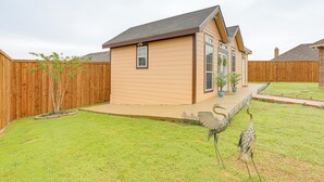 A single-story house with a sloped roof, a front porch, and a fenced backyard. - Seagoville Cottage w/ Yard - 15 Mi to Fair Park! (Seagoville)