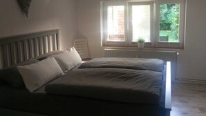Et soveværelse med en seng, et vindue og en radiator.