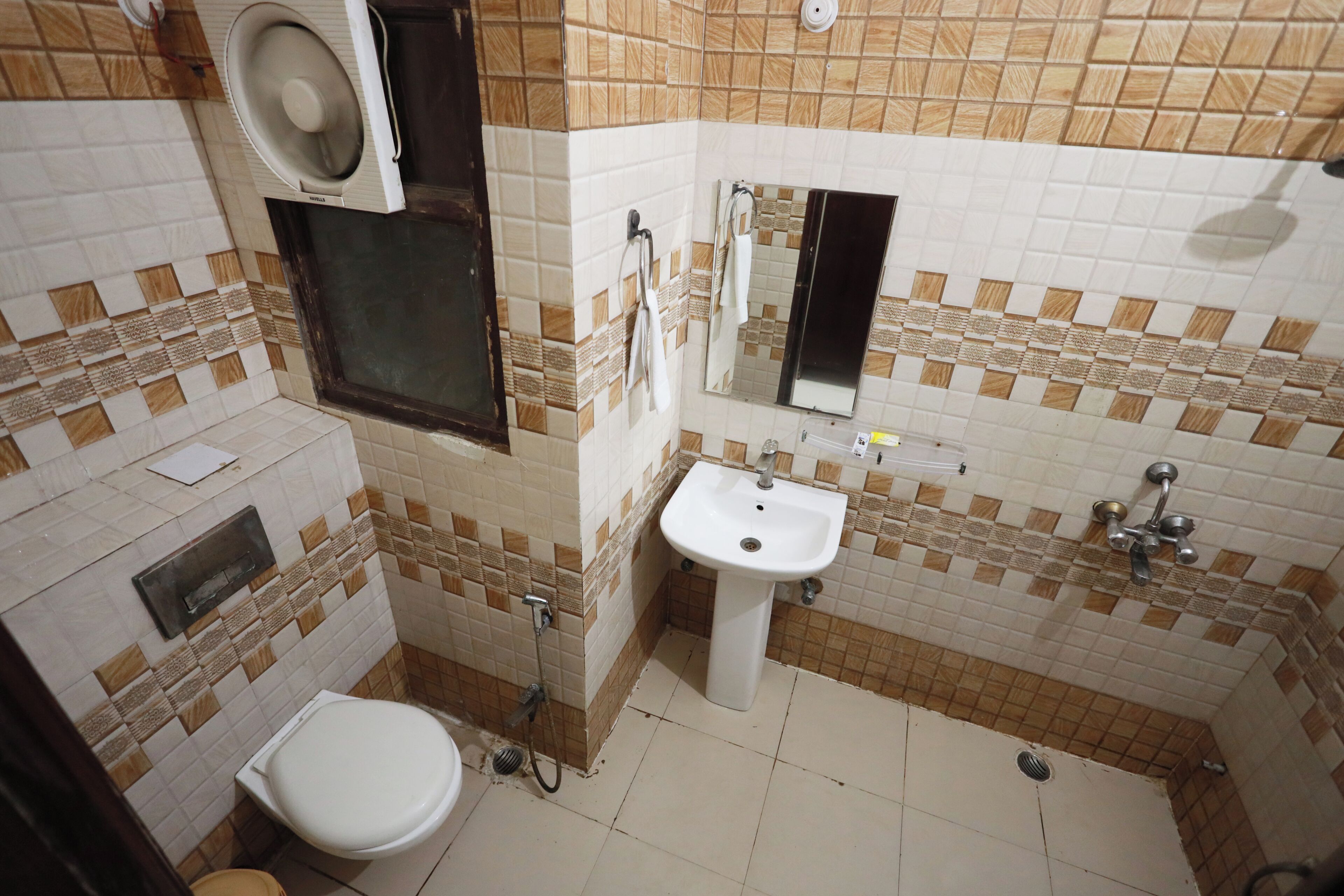 A small bathroom with a toilet, sink, and shower.