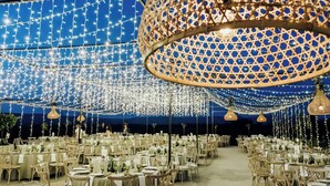 An outdoor dining area with string lights and hanging lamps. Tables are set with white tablecloths and chairs. - Casa Rural Obejuelo. Balcón de los Pedroches (VILLANUEVA DE CÓRDOBA)