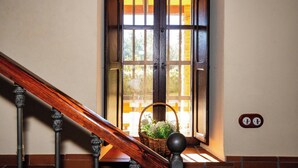 A wooden staircase with a basket of flowers on the landing. - Casa Rural Obejuelo. Balcón de los Pedroches (VILLANUEVA DE CÓRDOBA)