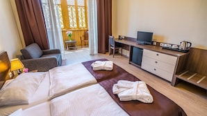 A hotel room with a bed, a desk, a TV, and a chair. - Hotel Gino Wellness Rabath (Akhaltsikhe)