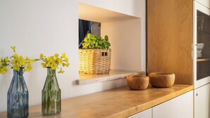 Un comptoir de cuisine orné de deux vases en verre, d’un panier en osier et de deux paniers tressés.