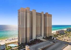 A high-rise hotel with a pool, beach view, and parking lot. - Tide Waters 416–Gulf Views–Sleeps 6 (Panama City Beach)