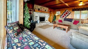 Una sala de estar acogedora con chimenea, un sofá y una mesita de centro.