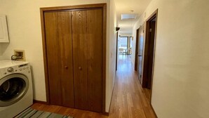 Un espace buanderie équipé d’un lave-linge et d’une armoire en bois.