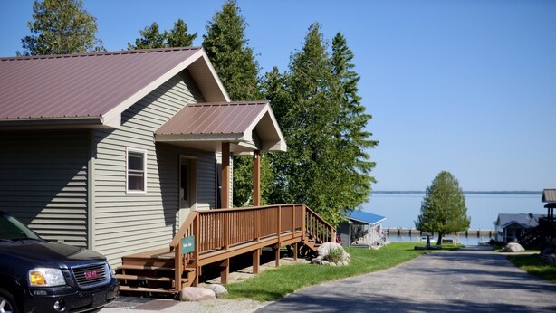 Un chalet doté d’une véranda, d’un quai et offrant une vue sur un lac.