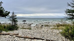 A rocky beach with a view of the ocean and distant land.