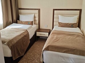 A hotel room with two beds, each with a headboard, a bedside table with a drawer, and a power outlet on the wall. - Gabala Bless Hotel Cottage (Gabala)