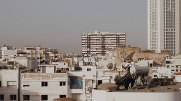 A rooftop with satellite dishes, a water tank, and a small structure.